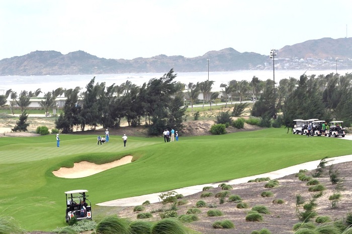 Sân golf ven biển Nhơn Hội Quy Nhơn với golfer và xe điện - ảnh minh họa